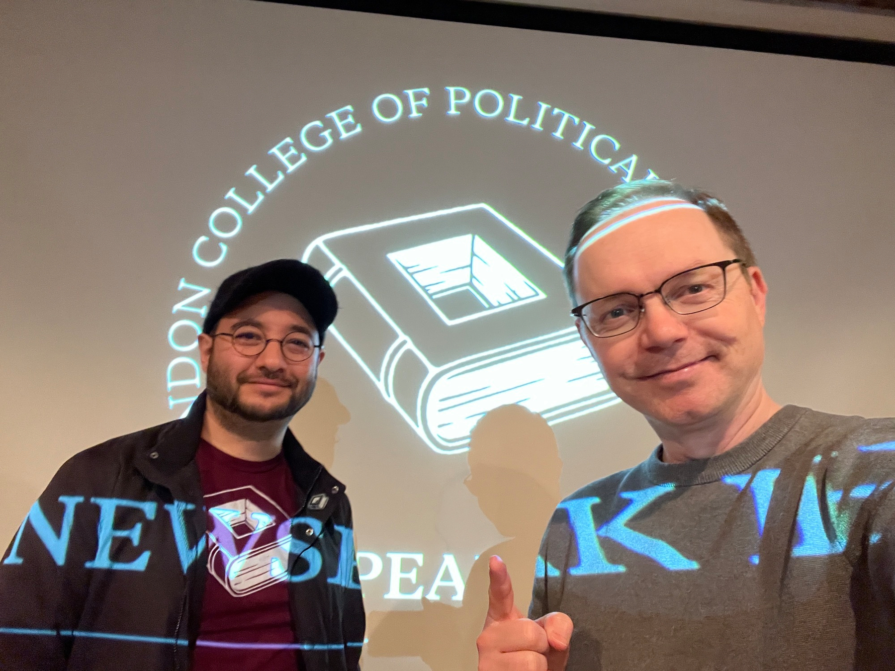 Ed Saperia and Chad selfie in front of a projected Newspeak House logo